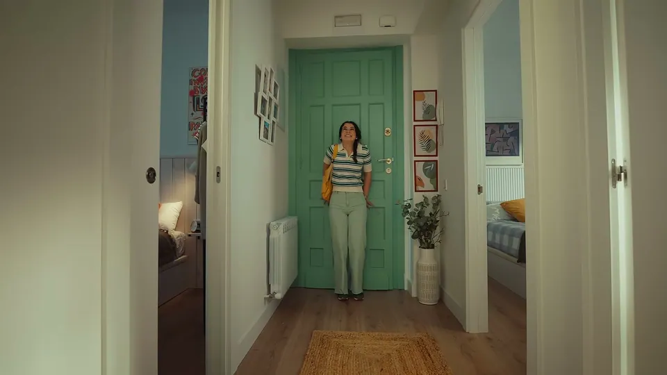 Una madre besa a su hijo en el recibidor de casa.