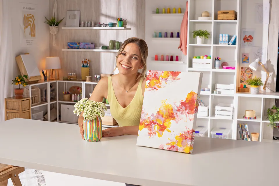 La presentadora en el set, con flores y lienzos.