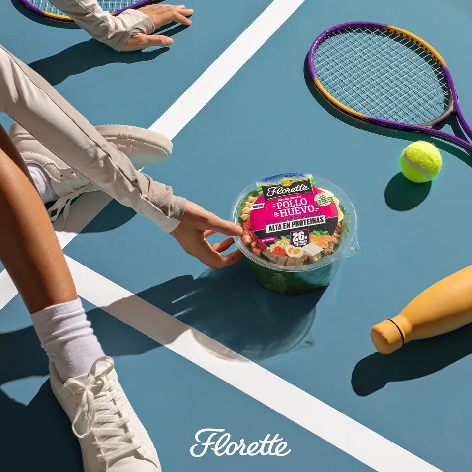 Ensalada Florette sobre una pista de tenis azul, con raqueta y pelota.