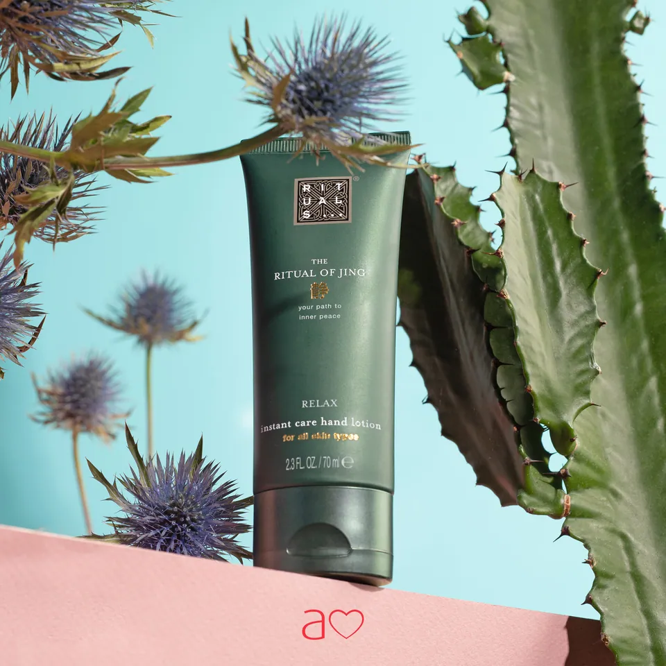 Crema de manos Rituals entre cardos y cactus, fondo celeste.